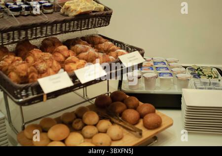 Un petit déjeuner buffet magnifiquement aménagé avec des croissants fraîchement préparés et des petits pains assortis avec yaourt et confitures dans Un petit déjeuner confortable Banque D'Images