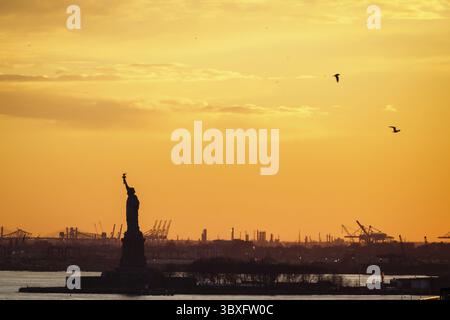 Coucher de soleil jaune sur la statue de la liberté Banque D'Images