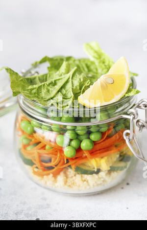 Bol en verre avec légumes frais crus et gruaux couscous.Préparation de repas sains - photos de préparation de recettes.Plats végétariens sains dans des récipients en verre.Poids Banque D'Images