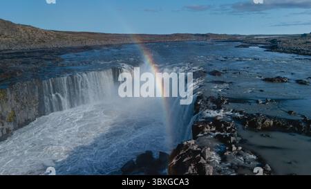 La cascade de Selfoss se jette majestueusement dans la rivière ci-dessous, accompagnée d'un arc-en-ciel époustouflant qui surplombe les chutes en Islande Banque D'Images