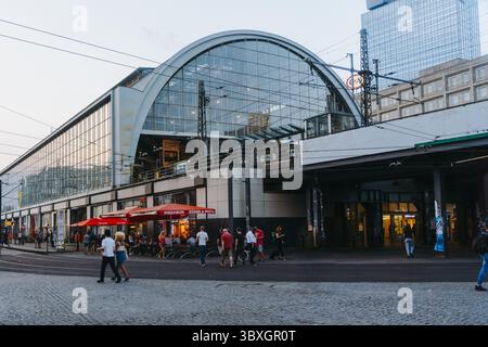 Berlin, Allemagne - 27 août 2019 : la vue sur la Hauptbahnhof brille de lumière chaude, projetant de longues ombres sur la rue pavée ci-dessous. Banque D'Images