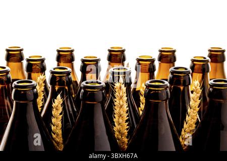 Des dizaines de bouteilles de bière allemandes brunes vides avec épillets de blé, isolées comme fond Banque D'Images