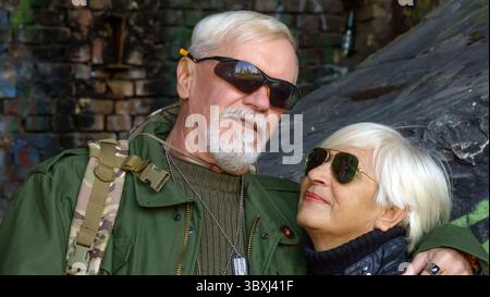 Portrait of elderly couple portant des lunettes de soleil sur fond de vieux murs de béton Banque D'Images