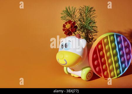 Jouet pop et vache jouet sur fond orange Banque D'Images