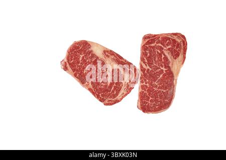 Deux steaks de bœuf à lame brute isolés sur fond blanc. Gros morceau de viande crue marbré, striploin sur blanc. Vue de dessus, gros plan Banque D'Images