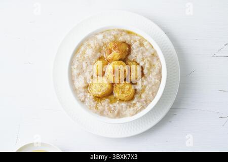 Flocons d'avoine entiers, grand bol de porridge avec banane caramélisée pour le petit déjeuner, repas du matin. Régime alimentaire sain végétalien DASH. Vue de dessus Banque D'Images