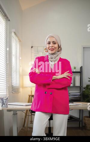 Femme d'affaires musulmane. femme d'affaires musulmane confiante en hijab debout avec les bras pliés près de son lieu de travail au bureau Banque D'Images