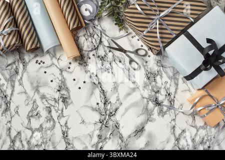 Différentes tailles, coloré, rayé et clair, marron, rose et blanc paquets cadeaux papier attachées avec des rubans noir et argent et s'incline sur une zone de marbre Banque D'Images