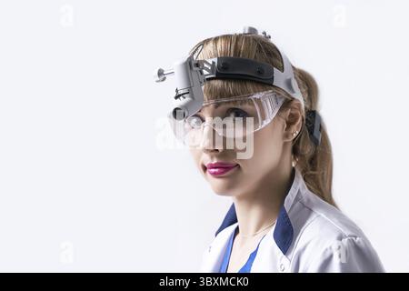 Médecin ORL confiant portant un phare chirurgical et des lunettes de protection. Portrait rapproché d'une femme oto-rhino-laryngologiste ou chirurgienne cervico-faciale Banque D'Images