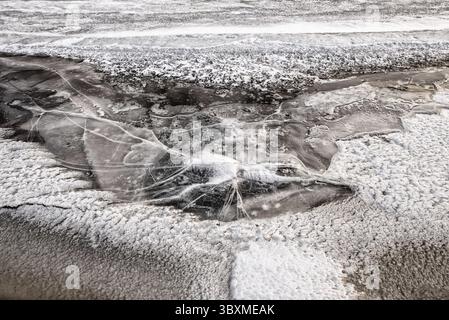 Regardez sur de la glace d'eau fissurée gelée avec dans le givre hiver Banque D'Images