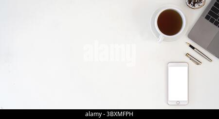 Smartphone vue de dessus avec écran vide, ordinateur portable et tasse à café sur le bureau. Copiez l'espace pour votre texte Banque D'Images