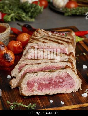 Régime keto cétogène steak grillé de boeuf frit, striploin à bord de la table brun foncé. Recette de nourriture Paleo avec morceau de moi grillé haché Banque D'Images
