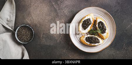 Nourriture, délicieux sandwichs avec ricotta et caviar de chia noir sur une assiette sur la bannière Web vue sur le dessus de table Banque D'Images