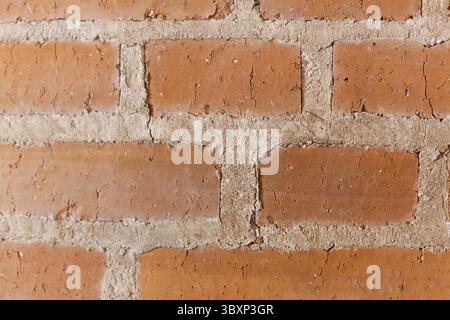Un mur de briques avec une ligne blanche au milieu. Le mur est fait de briques rouges. Les briques ne sont pas parfaitement alignées Banque D'Images