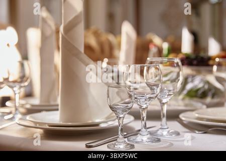 Table couverte festive avec couverts, beaux verres et une serviette dans le restaurant Banque D'Images