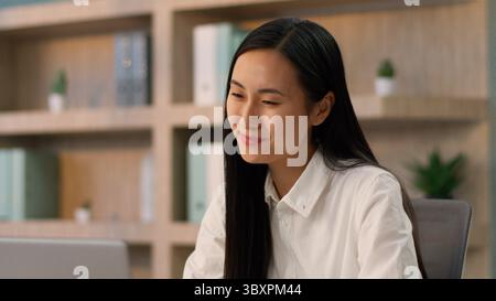 Positive asiatique fille japonaise ouvrière de bureau employeur gestionnaire des ressources humaines femme d'affaires joyeuse femme d'affaires coréenne parlant en ligne ordinateur d'appel vidéo Banque D'Images