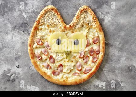 Délicieux menu pizza fine pour enfants avec sauce au fromage à la crème, poulet, saucisse de Vienne et museau de chouette de tranches d'ananas, olives noires, piquant Banque D'Images