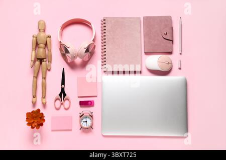 Composition avec ordinateur portable moderne et fournitures scolaires sur fond rose Banque D'Images