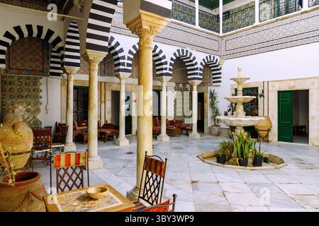 Cour décorée de carreaux et d'arcades colorées à colonnes dans l'historique palais Dar Bach Hamba dans la médina de Tunis, Tunisie Banque D'Images