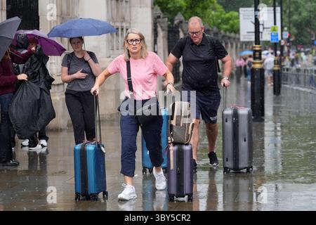 Des gens marchant sous la pluie dans le centre de Londres. Un avertissement météorologique orange est entré en vigueur avec des orages dangereux menaçant d'entraîner un week-end d'inondations dans certaines parties du Royaume-Uni. Date de la photo : samedi 19 juillet 2025. Banque D'Images