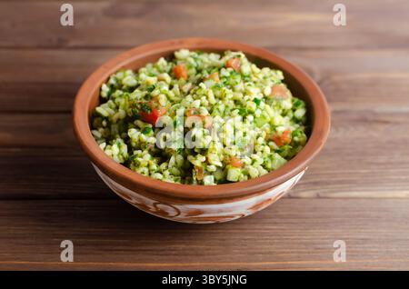 Salade orientale Tabbouleh dans un bol en céramique sur une table en bois. Concept de cuisine traditionnelle libanaise ou syrienne. Plat végétarien ou végétalien. style rustique Banque D'Images