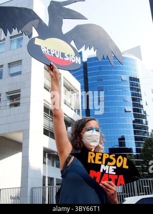 22 janvier 2022, Lima, Pérou : ''Repsol me tue'' peut être lu sur une bannière tenue par une femme lorsque des dizaines de manifestants se rassemblent devant les bureaux de Repsol au Pérou pour protester contre la récente marée noire qui a causé une catastrophe écologique sur les côtes de Lima et El Callao. Le 15 janvier, au milieu des vagues anormales produites par l’éruption du volcan Tonga, plus de 6 000 barils de pétrole ont été déversés en mer à la raffinerie de la Pampilla exploitée par Repsol, une compagnie pétrolière espagnole, générant l’une des plus grandes catastrophes écologiques des dernières décennies au Pérou. (Crédit image : © Carlos GARC Banque D'Images