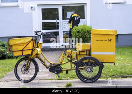 Facteur, Deutsche Post, distribue le courrier dans un immeuble, tricycle électrique, Rhénanie du Nord-Westphalie, Allemagne Banque D'Images