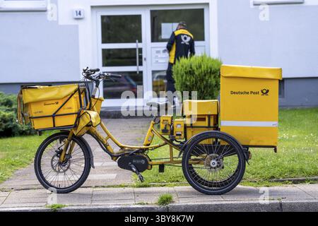 Facteur, Deutsche Post, distribue le courrier dans un immeuble, tricycle électrique, Rhénanie du Nord-Westphalie, Allemagne Banque D'Images