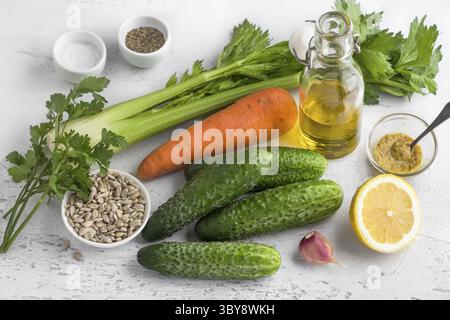 Nourriture, ingrédients d'une délicieuse salade végétalienne ou autre plat : céleri, carottes, concombres frais, graines de tournesol, persil, ail, citron, huile d'olive Banque D'Images