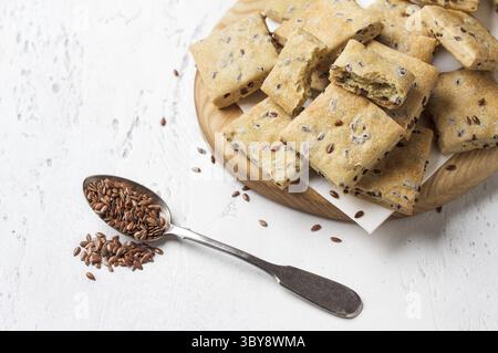 Nourriture, gros plan de craquelins de lin faits maison sur une planche de bois, parsemés de graines de lin, collation saine et nutritive, espace de copie Banque D'Images