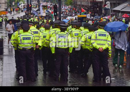 Londres, Angleterre, Royaume-Uni. 19 juillet 2025. Des policiers observent des milliers de personnes qui défilent dans le centre de Londres en solidarité avec la Palestine alors qu’Israël poursuit ses attaques contre Gaza. Crédit : ZUMA Press, Inc/Alamy Live News Banque D'Images