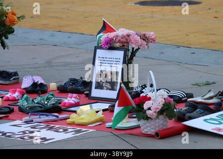 Un mémorial avec des chaussures pour enfants, des drapeaux palestiniens et des bougies est aménagé lors d’une manifestation organisée par Burbank pour la Palestine, le 16 juillet 2025. Banque D'Images