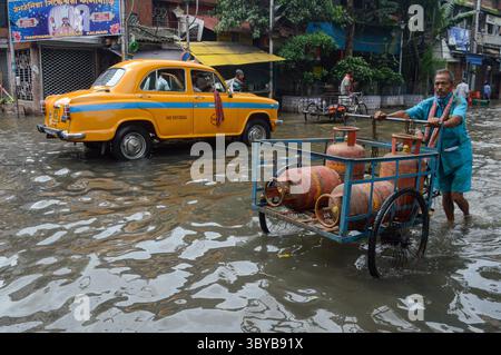 30 juillet 2021, Kolkata, Inde : un travailleur transporte une bouteille de gaz GPL dans une rue inondée de Kolkata , Inde , le 30 juillet 2021. Les prix des bouteilles de gaz GPL ont augmenté de plus de 140 roupies au cours des 6 derniers mois, en raison de la hausse des prix du pétrole brut (crédit image : © Debarchan Chatterjee/ZUMA Press Wire) Banque D'Images