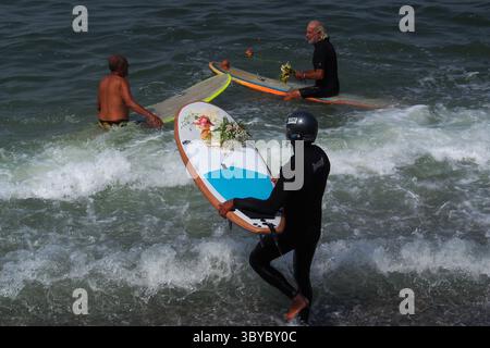 19 février 2022, Lima, Lima, Pérou : un surfeur porte une offrande de fleurs sur sa planche lorsque, comme action de protestation contre la marée noire de Repsol qui a causé une catastrophe écologique sur les côtes de Lima et El Callao, un groupe de militants a organisé une cérémonie de mariage avec la mer sur la plage de Makaha à Lima. Le 15 janvier, plus de 10 000 barils de pétrole ont été déversés en mer à la raffinerie de la Pampilla exploitée par Repsol, une compagnie pétrolière espagnole, générant l’une des plus grandes catastrophes écologiques au Pérou. (Crédit image : © Carlos Garcia Granthon/ZUMA Press Wire) Banque D'Images