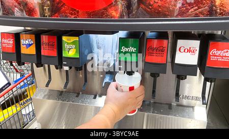 Ottawa, ON Canada - 19 juillet 2025 : distributeur de boissons présentant des produits Coca-Cola à Costco Food court avec une main remplissant un gobelet de soda. trantio Banque D'Images