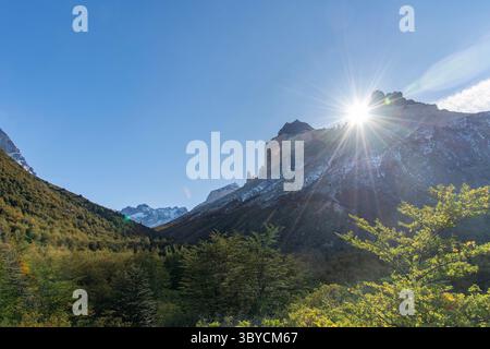Soleil brillant se levant juste au-dessus des cornes enneigées de la formation de Paine dans le massif de Paine, parc national de Torres del Paine, Patagonie, Chili entre les Banque D'Images
