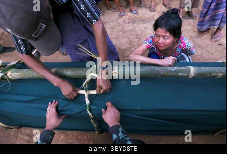 20 février 2022, Karen Sate, Birmanie Myanmar : la mère du combattant de la KNLA mort le pleure alors que sa famille et ses camarades attachent la boîte contenant son corps à un grand poteau de bambou fraîchement coupé qui sera utilisé pour le transporter à sa crémation à l'extérieur de l'avant-poste de la KNLA. Plus tôt dans la journée, le soldat de l'Armée de libération nationale Karen (KNLA), âgé de 26 ans, a été tué en combattant sur les lignes de front contre l'armée birmane. La KNLA se bat contre le gouvernement de Birmanie/Myanmar depuis 1949 dans ce que les historiens disent être la guerre civile la plus longue de l'histoire moderne. (Crédit image : © Thomas James Hurst/ZUMA Press Banque D'Images