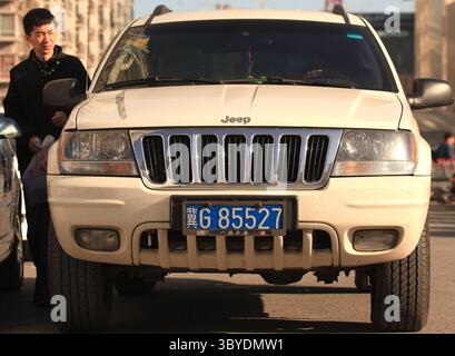 16 décembre 2011, PÉKIN, CHINE : un Chinois déverrouille la porte d'une Jeep Grand Cherokee américaine garée près d'un parking d'un centre commercial à Pékin le 16 décembre 2011. La Chine imposera des droits punitifs allant jusqu'à 22 pour cent sur les grandes voitures et les VUS exportés des États-Unis, a déclaré le ministère chinois du commerce plus tôt cette semaine, le dernier d'une série de différends commerciaux entre les deux plus grandes économies du monde. (Crédit image : © Stephen Shaver/ZUMA Press Wire) Banque D'Images