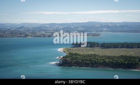 Baie marine avec péninsule verdoyante, ville côtière et montagnes en toile de fond, Tauranga, Nouvelle-Zélande Banque D'Images