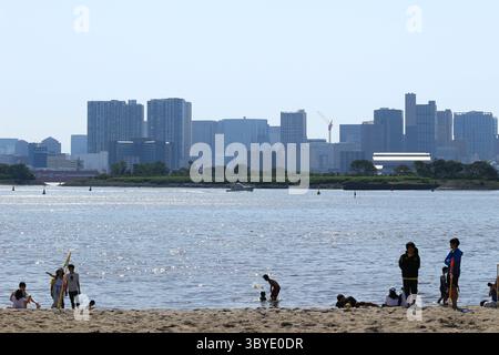 Vie quotidienne au Japon les familles et les couples apprécient la vie de plage sur la plage de sable artificiel à Odaiba Seaside Park Banque D'Images