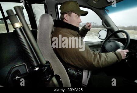 27 février 2002 - États-Unis - KRT US NEWS STORY SLUGGED : USCANADA-3 KRT PHOTOGRAPHIE PAR DALE GULDAN/MILWAUKEE JOURNAL SENTINEL (CHICAGO ET WISCONSIN JUSQU'AU 8 AVRIL) (mars 25) chevauchant avec un fusil de chasse de 12 gages pour le renfort, Daniel Salyers, agent de patrouille responsable de la patrouille frontalière américaine à Pembina, Dakota du Nord, repousse les grands espaces près de la frontière canadienne. (MW) BL NC KD 2002 (Horiz) (lde) (crédit image : © Milwaukee Journal Sentinel via ZUMA Press Wire) Banque D'Images