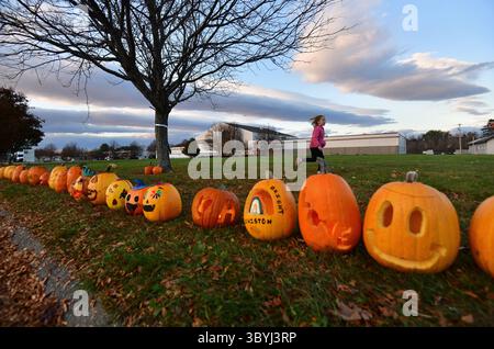 5 novembre 2023, Monmouth, Maine, États-Unis : un hommage à la citrouille communautaire juste-à-temps a eu lieu comme une journée de guérison sur le site de bowling d'une fusillade de masse à Lewiston. Au moins 18 personnes ont été tuées dans l'assaut. C’était pour honorer Thomas Conrad, l’une des victimes qui avait planifié l’événement pour sa fille de 9 ans qui aimait les citrouilles. Plus de 800 citrouilles aux bougies scintillantes bordaient la route, Makenzie Therrien (7) court dans l'herbe derrière. (Crédit image : © Carol Guzy/ZUMA Press Wire) Banque D'Images