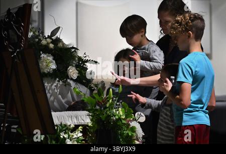 8 novembre 2023, South Portland, Maine, États-Unis : ELIZABETH SEAL et les enfants JAXTON 3, JARROD 6, SEPHINE 9 et JAYSON 12 utilisent la langue des signes pour 'I Love You' pour faire un dernier adieu à Joshua Seal, 36 un interprète ASL tué par un tireur de masse Lewiston au Schemengees Bar dans la salle vide après les funérailles à South Portland. Le bar organisait un tournoi Cornhole pour les membres de la communauté sourde lorsque le tireur est entré, tuant 18 personnes. Il laisse derrière lui sa femme Elizabeth Seal et ses quatre enfants. (Crédit image : © Carol Guzy/ZUMA Press Wire) Banque D'Images