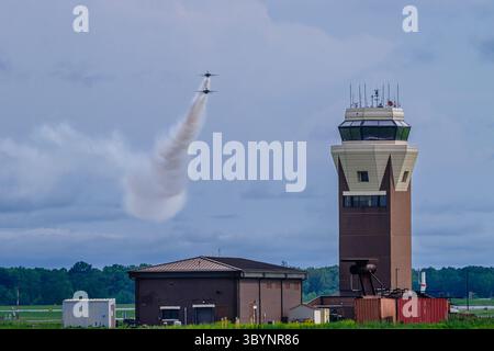 Deux Thunderbirds de l'USAF effectuent une manœuvre miroir à côté de la tour de contrôle du trafic aérien, traînant de la fumée à McGuire AFB, New Jersey, le 16 mai 2025. Banque D'Images
