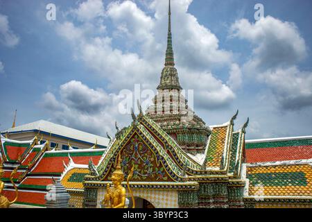 Belle porte d'entrée avec guerriers gardiens dorés de l'un des temples du Grand Palais à Bangkok, Thaïlande Banque D'Images