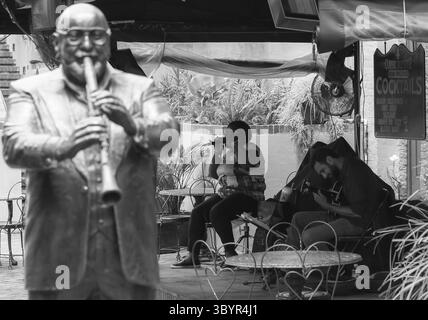 New Orleans, États-Unis - 14 mai 2015 : Statue du clarinettiste Pete Fountain dans musical Legends Park, dans les tables du café arrière et un groupe jouant de la musique live. T Banque D'Images
