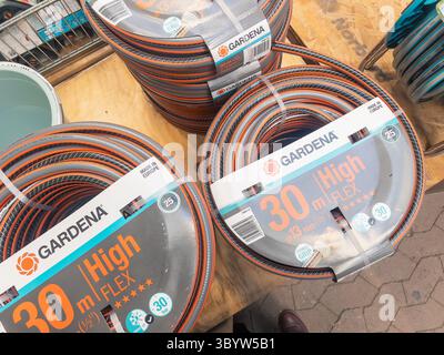 Porsgrunn, Norvège - 06 avril 2025 : les tuyaux d'arrosage GARDENA sont soigneusement disposés en magasin, avec des couleurs vives et un emballage durable pour une efficacité optimale Banque D'Images