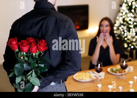 Jeune homme donnant des roses rouges à une femme Banque D'Images