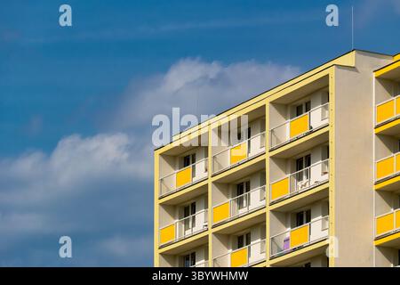 Façade d'appartement minimaliste jaune et blanche avec balcons répétés Banque D'Images