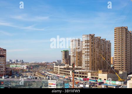 Vue panoramique d'une ville moderne avec des immeubles de grande hauteur et des projets de construction en cours par temps clair.Russie, Krasnodar-11.03.2025 Banque D'Images